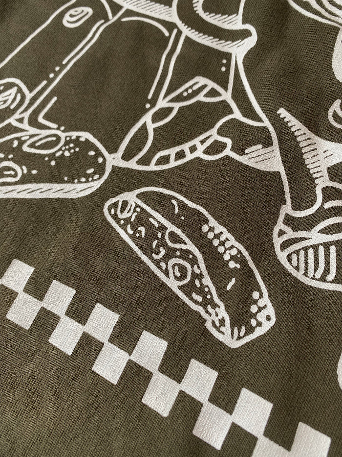 Nahaufnahme des Cappuccino Sweater, weißer Druck auf grünem Stoff, nachhaltige Mode von Koohl's